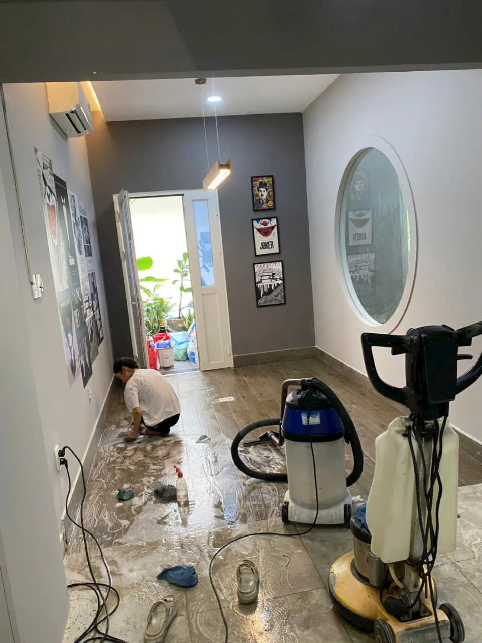 nhân viên dùng máy hút bụi công nghiệp dọn sạch trần tường